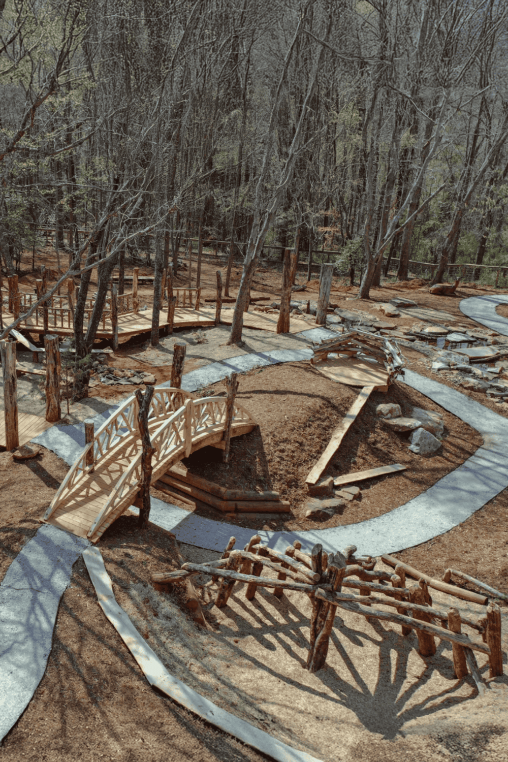 Handcrafted wooden park with pathways and bridges in a forest setting.