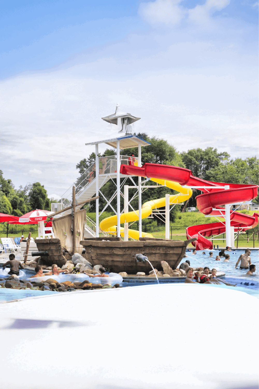 Water park with colorful water slides and pirate-themed splash area, perfect for family fun and outdoor adventure.
