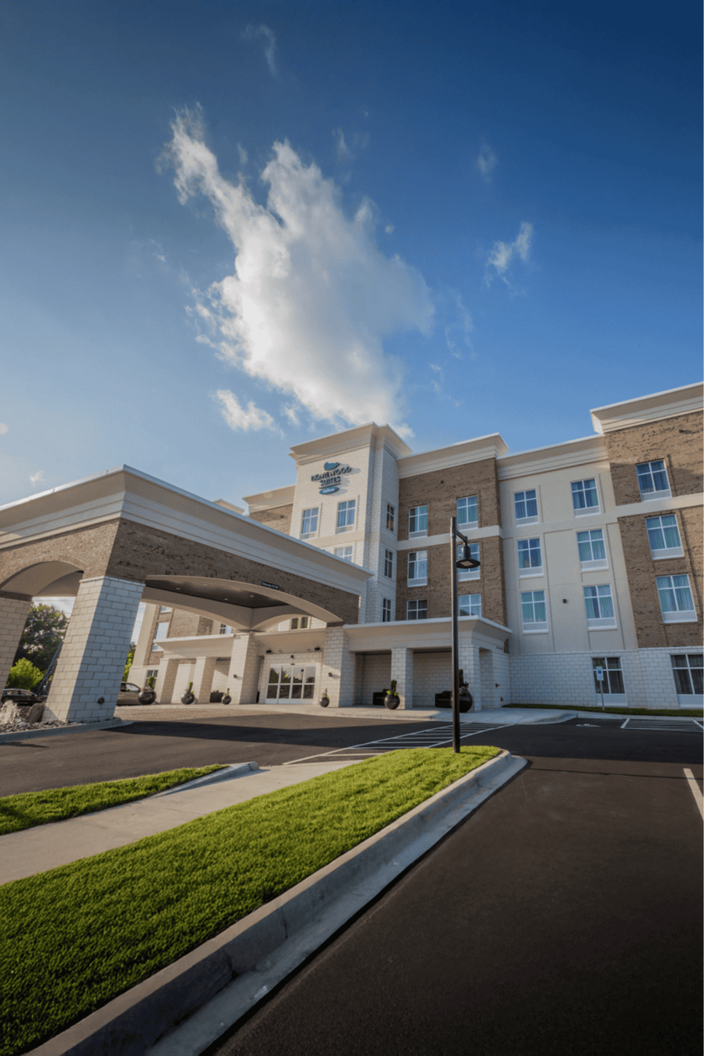 Modern hotel exterior with welcoming entrance and landscaped surroundings, perfect for a comfortable stay.