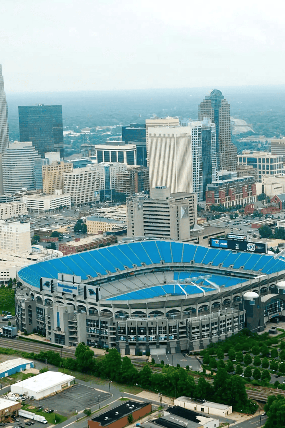 Downtown Dallas skyline with AT&T Stadium in foreground, featuring city skyscrapers and urban landscape.