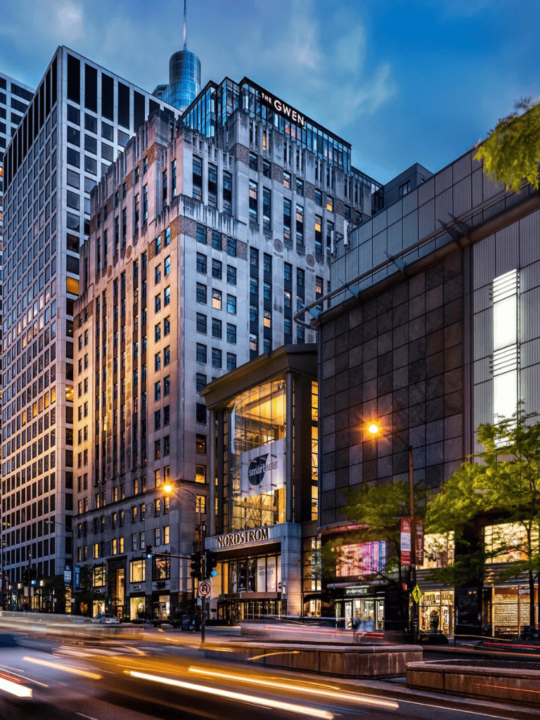Downtown city buildings with modern architecture and vibrant city lights at dusk.