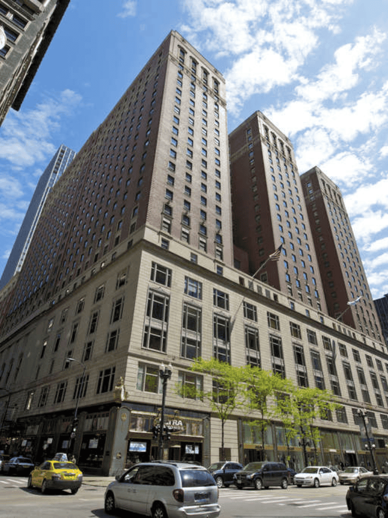 Imposing downtown skyscraper with modern architecture and bustling city street scene.