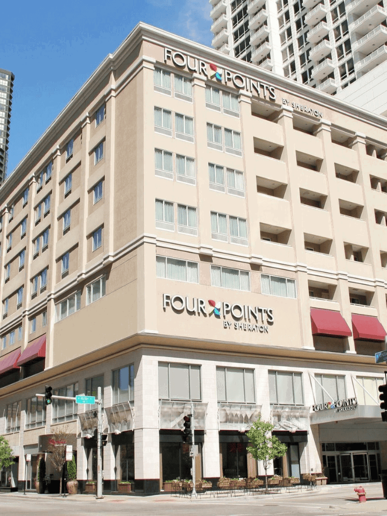 Modern Four Points by Sheraton hotel in an urban downtown area with high-rise buildings.