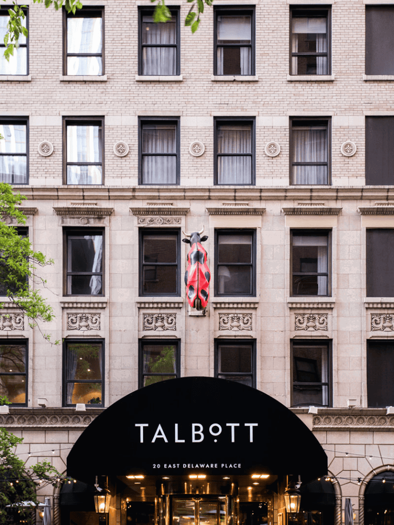 Vibrant red and black decorative horse sculpture on historic building in downtown city.