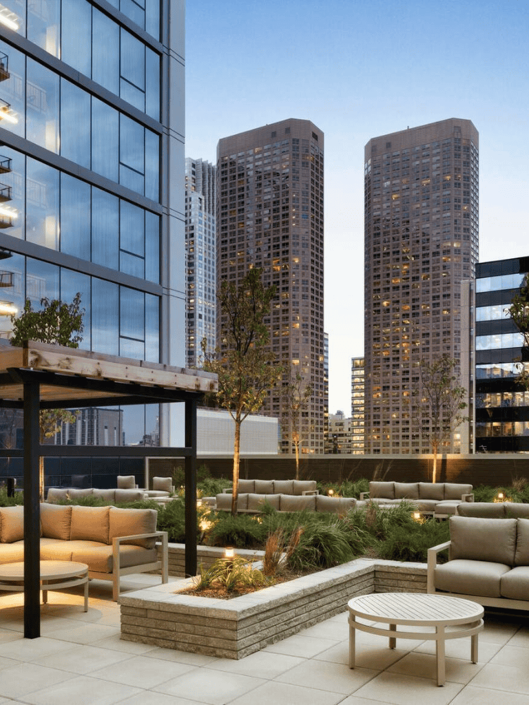 Modern rooftop cityscape with high-rise buildings and outdoor lounge area, perfect for urban living.