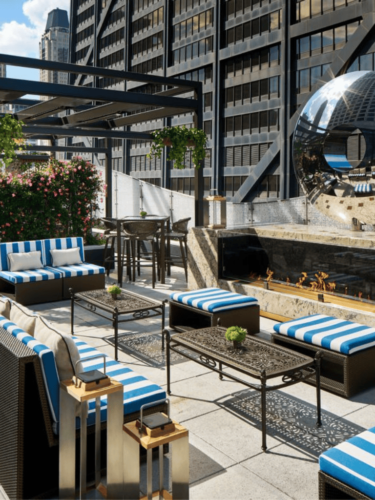 Outdoor rooftop lounge with modern city skyline views, stylish seating, and fire feature at QuestForDirections.