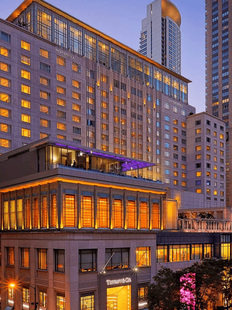 Luxurious hotel building with Tiffany & Co store in downtown city at dusk, illuminated windows and modern architecture.