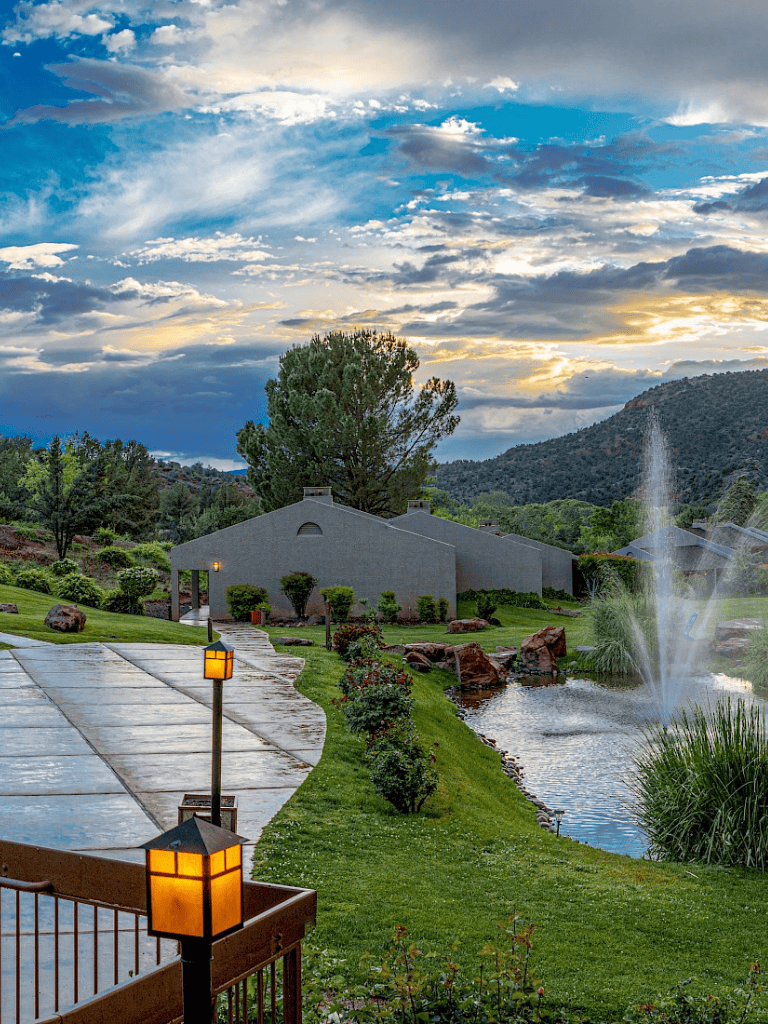 Serene lakeside setting with lush greenery, fountain, and scenic mountain views at QuestForDirections.