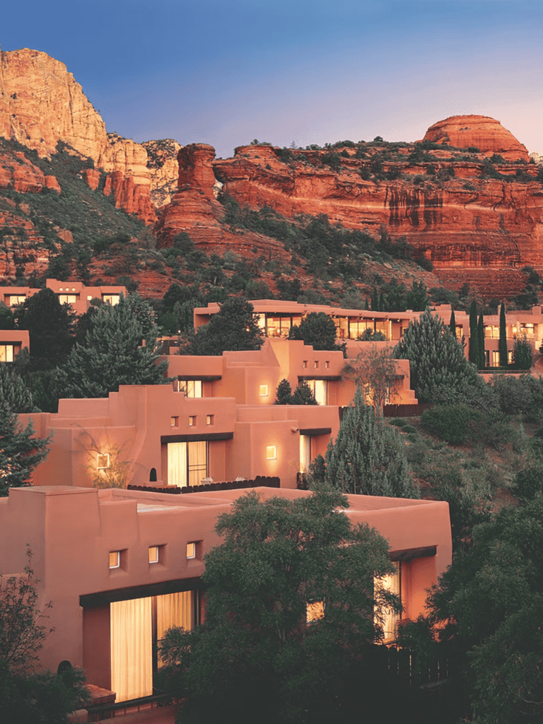 Secluded desert town with modern adobe-style homes and red rock formations at sunset.