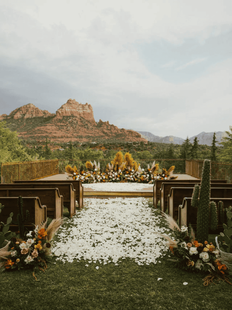 Vow renewal ceremony setup with mountain view, floral arrangements, and wedding aisle in a scenic outdoor location.