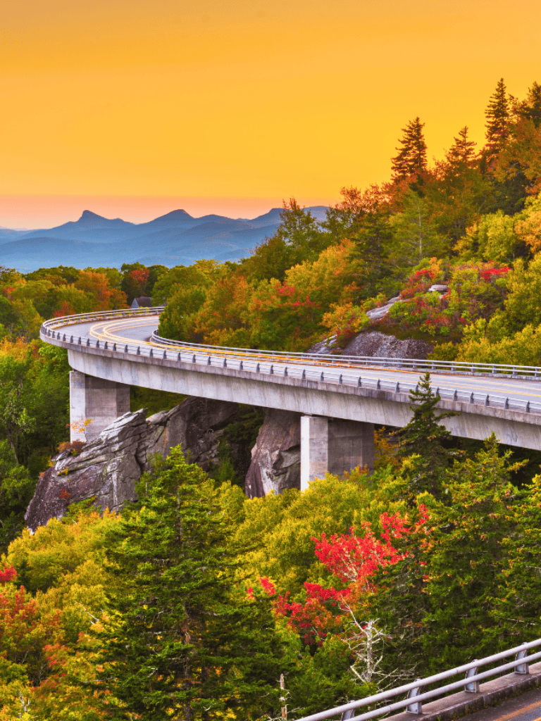 Vibrant autumn landscape with scenic mountain highway and colorful foliage.