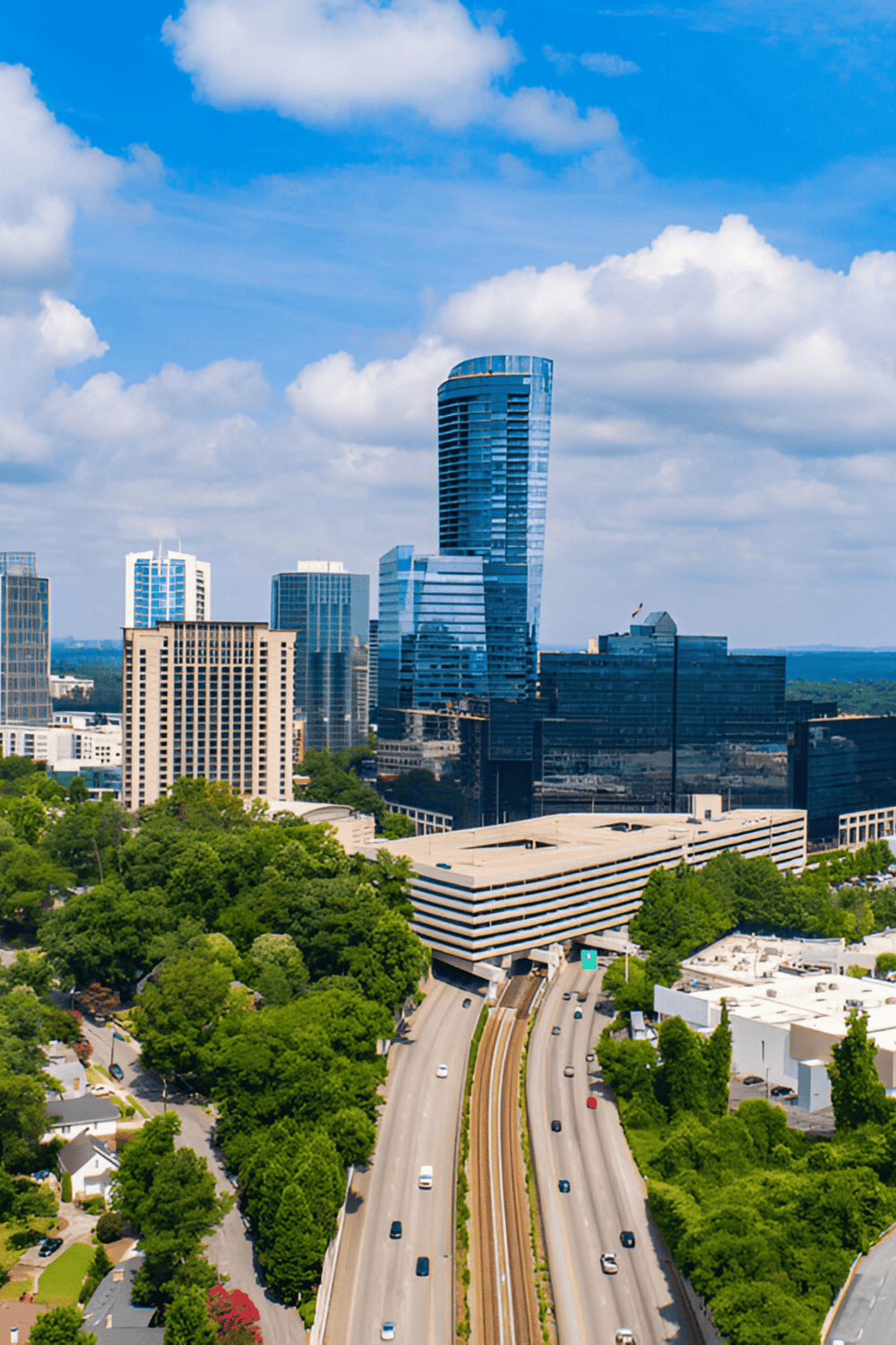 Contemporary city skyline with tall glass skyscrapers, vibrant blue sky, and lush green trees.