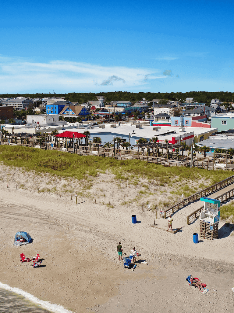 Colorful coastal town with sandy beach and vibrant buildings by the shoreline.