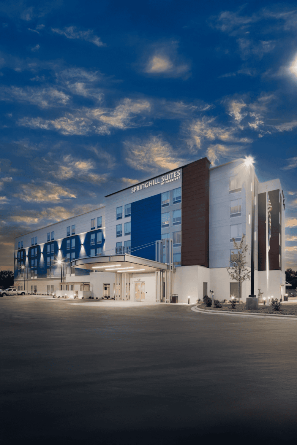 Modern SpringHill Suites hotel exterior at sunset, showcasing contemporary architecture and inviting entrance.