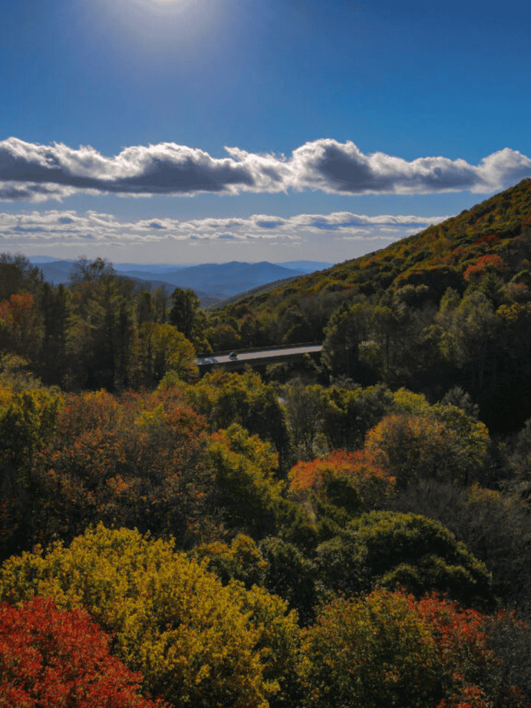 Scenic mountain landscape with vibrant fall foliage and a clear sky, perfect for travel and outdoor adventure.