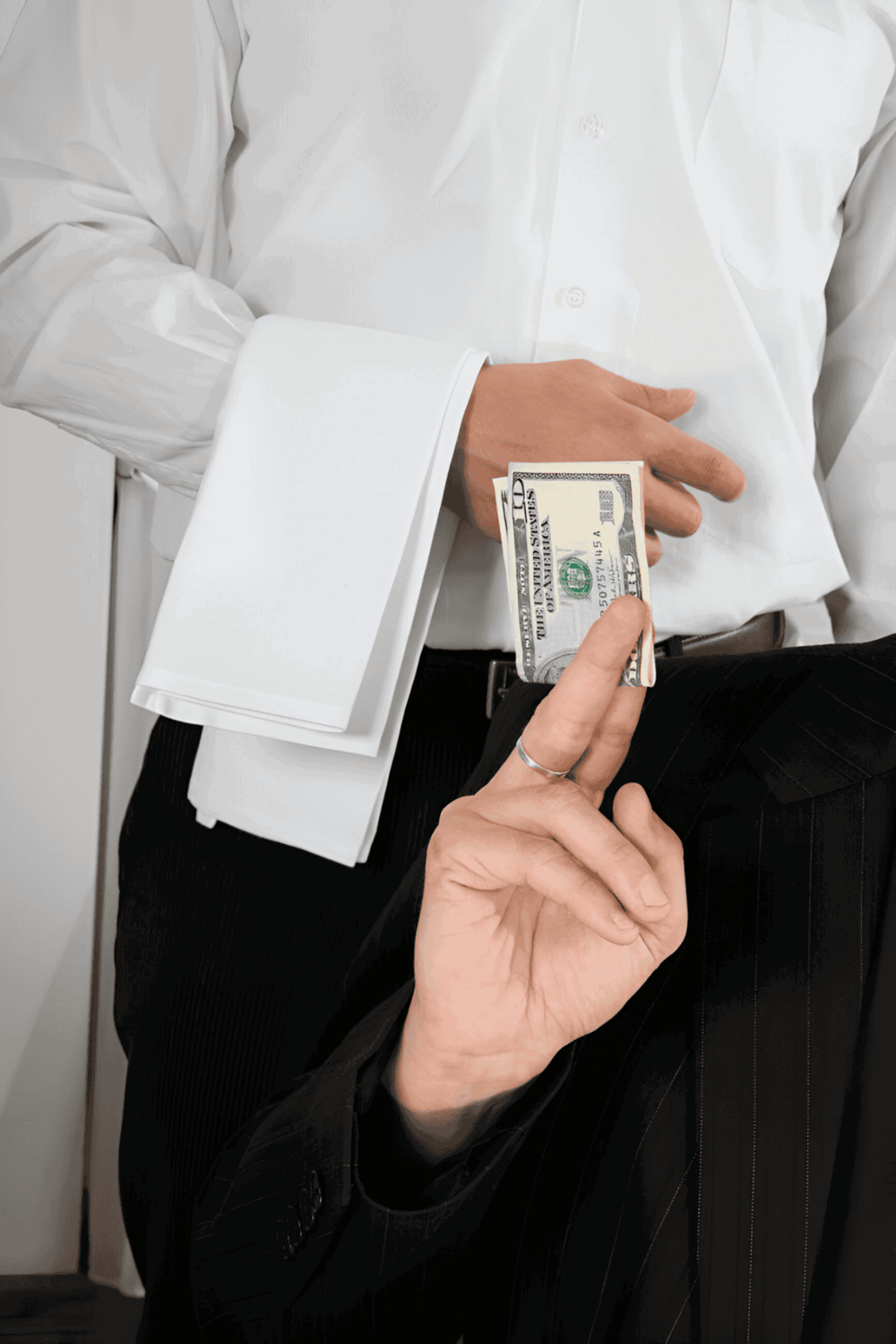 Bribery and corruption concept with unbuttoned shirt, money and hand gesture.