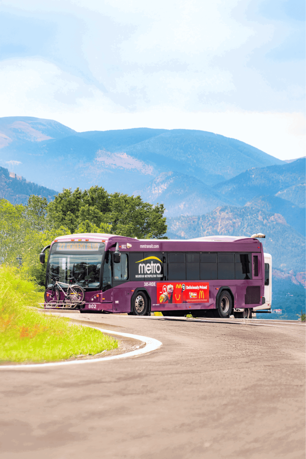 Public transit mountain metro bus with bike rack in scenic mountain landscape, sustainable travel in Colorado.