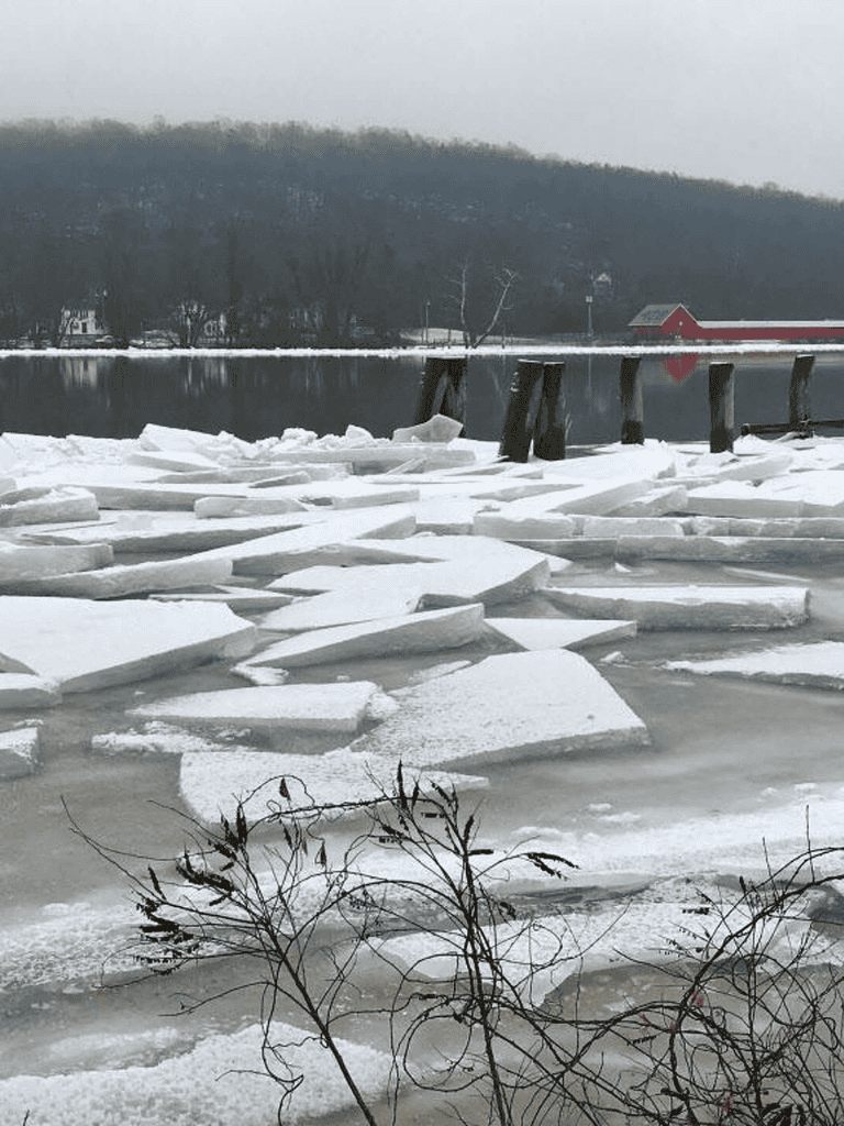 Frozen lake with breaking ice, snow-covered landscape, and scenic winter views for travel and outdoor adventure.
