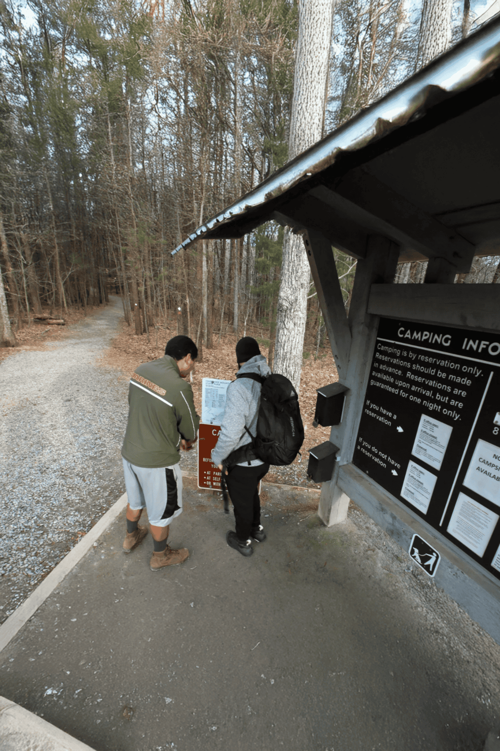 Great Outdoors camping reservation information at woods trailhead.