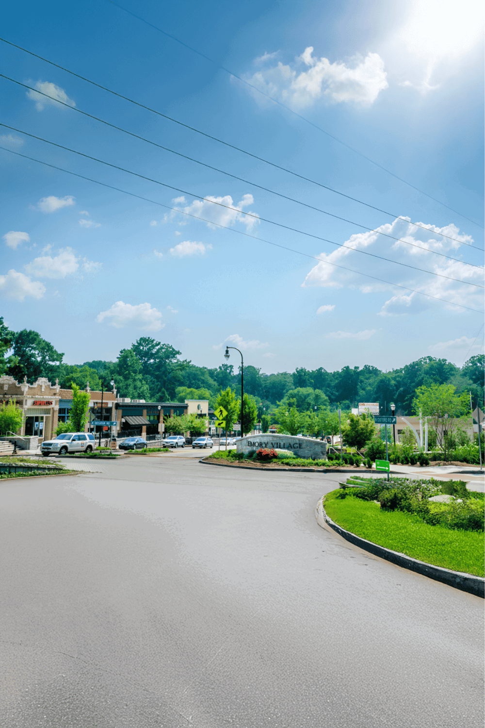Emory Village shopping and dining area in a scenic suburban setting with trees and blue sky.
