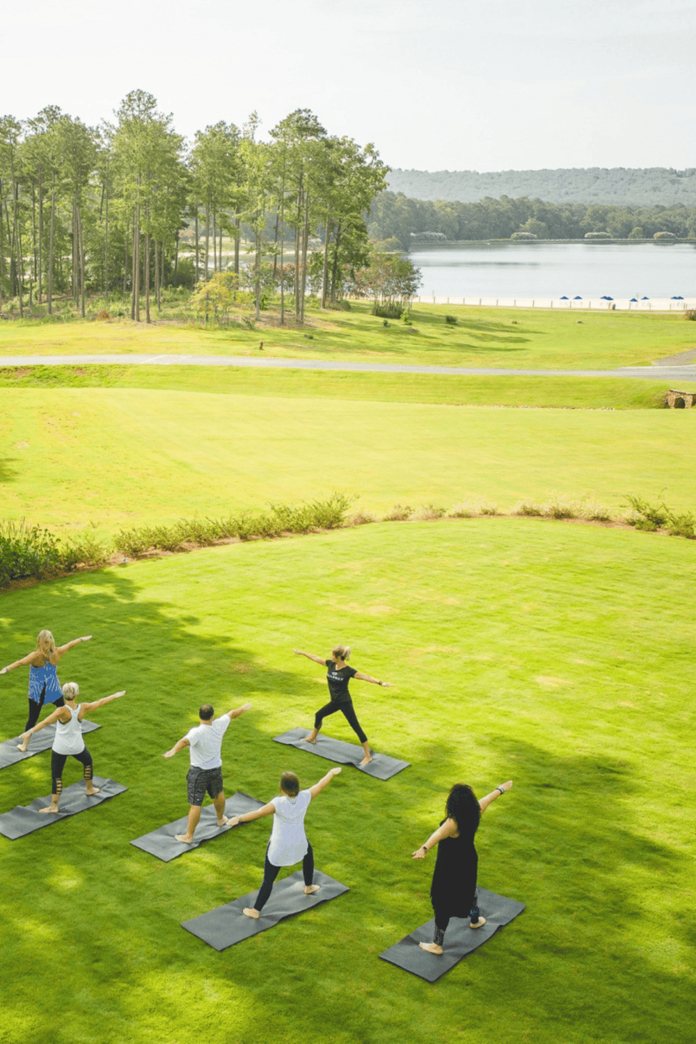 Yoga in scenic outdoor location near water and trees, promoting relaxation and wellness.
