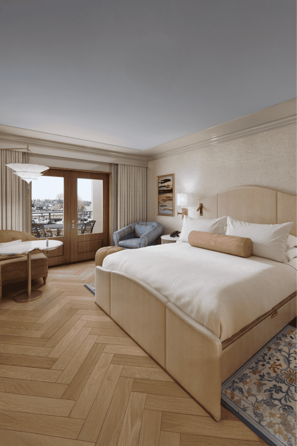 Cozy hotel bedroom with balcony view, modern decor, and comfortable furnishings in a welcoming atmosphere.