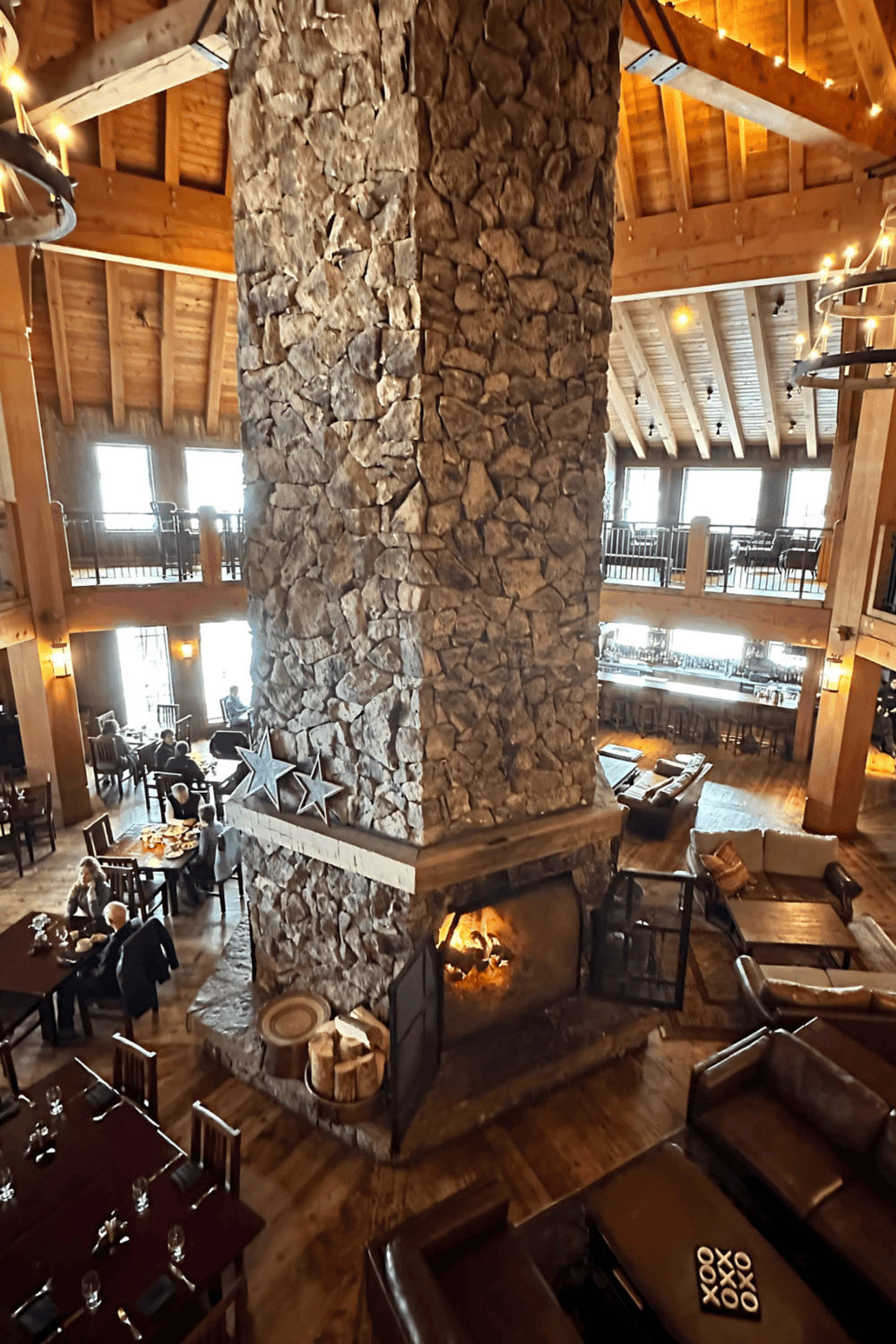 Warm cozy lodge interior with a large stone fireplace and inviting seating area, perfect for relaxing and socializing.