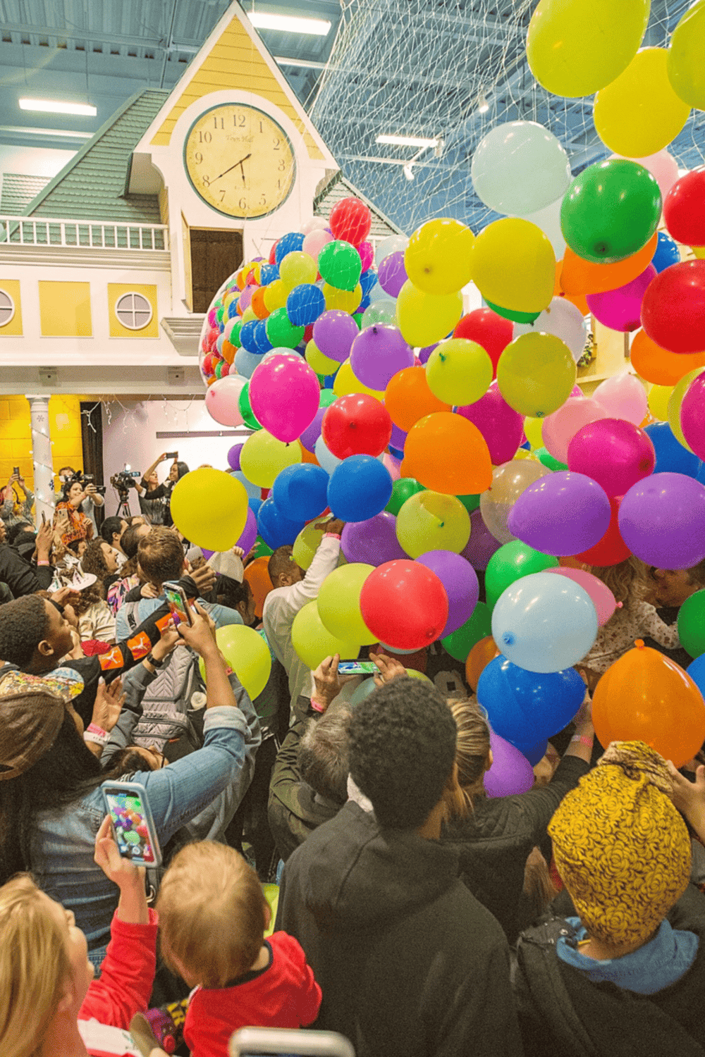 Vibrant indoor event with colorful balloons and children celebrating, organized by QuestForDirections.