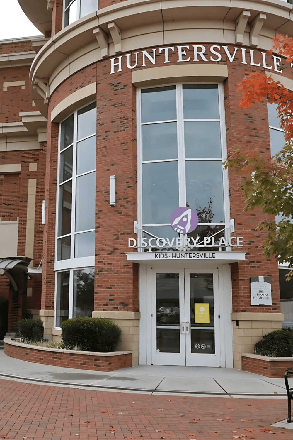 Accessible kids' discovery center at Huntersville, outdoor view of modern brick building with large windows.