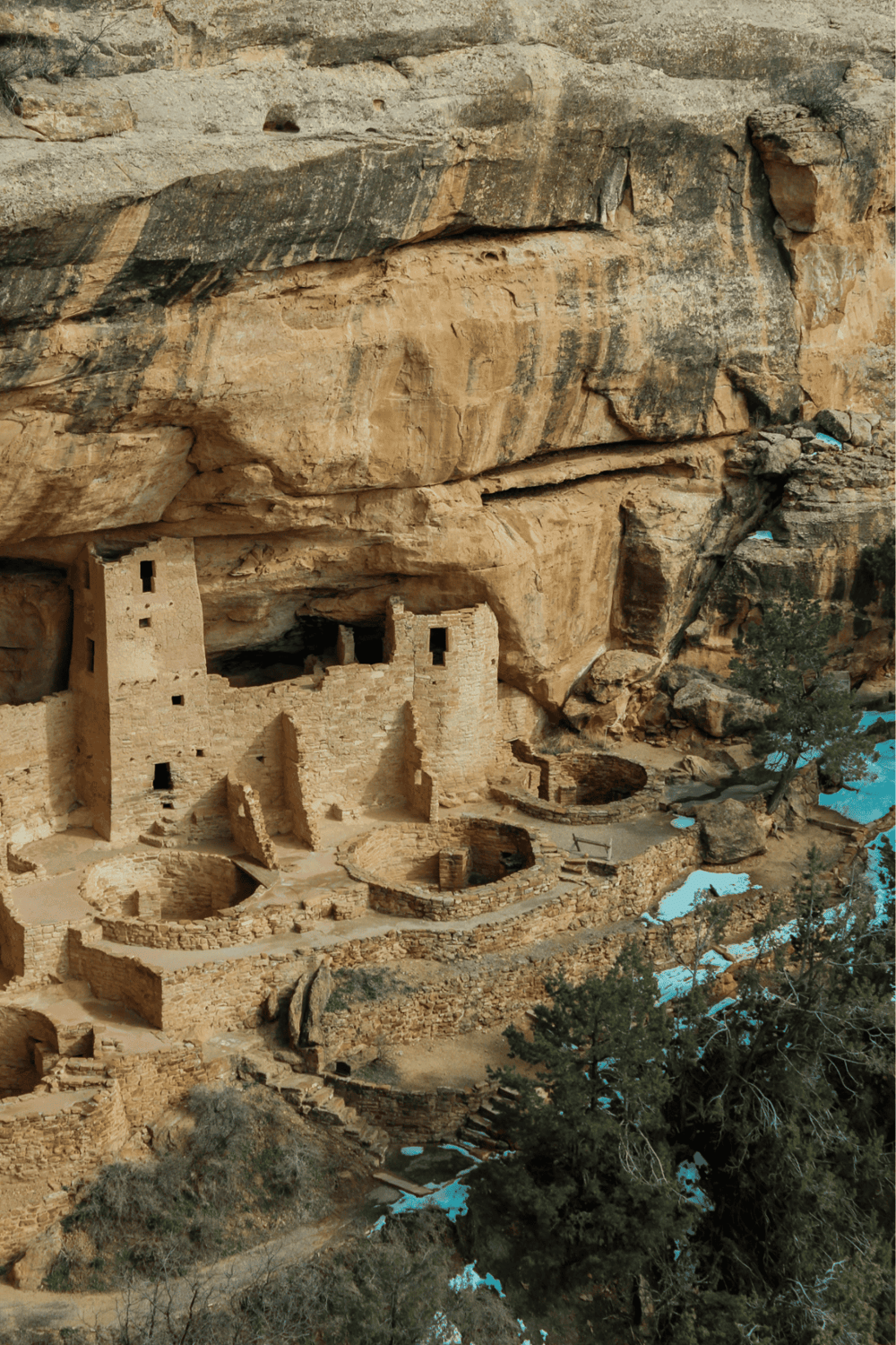 Ancient cliff dwelling at Mesa Verde National Park with rock formations and Native American ruins.