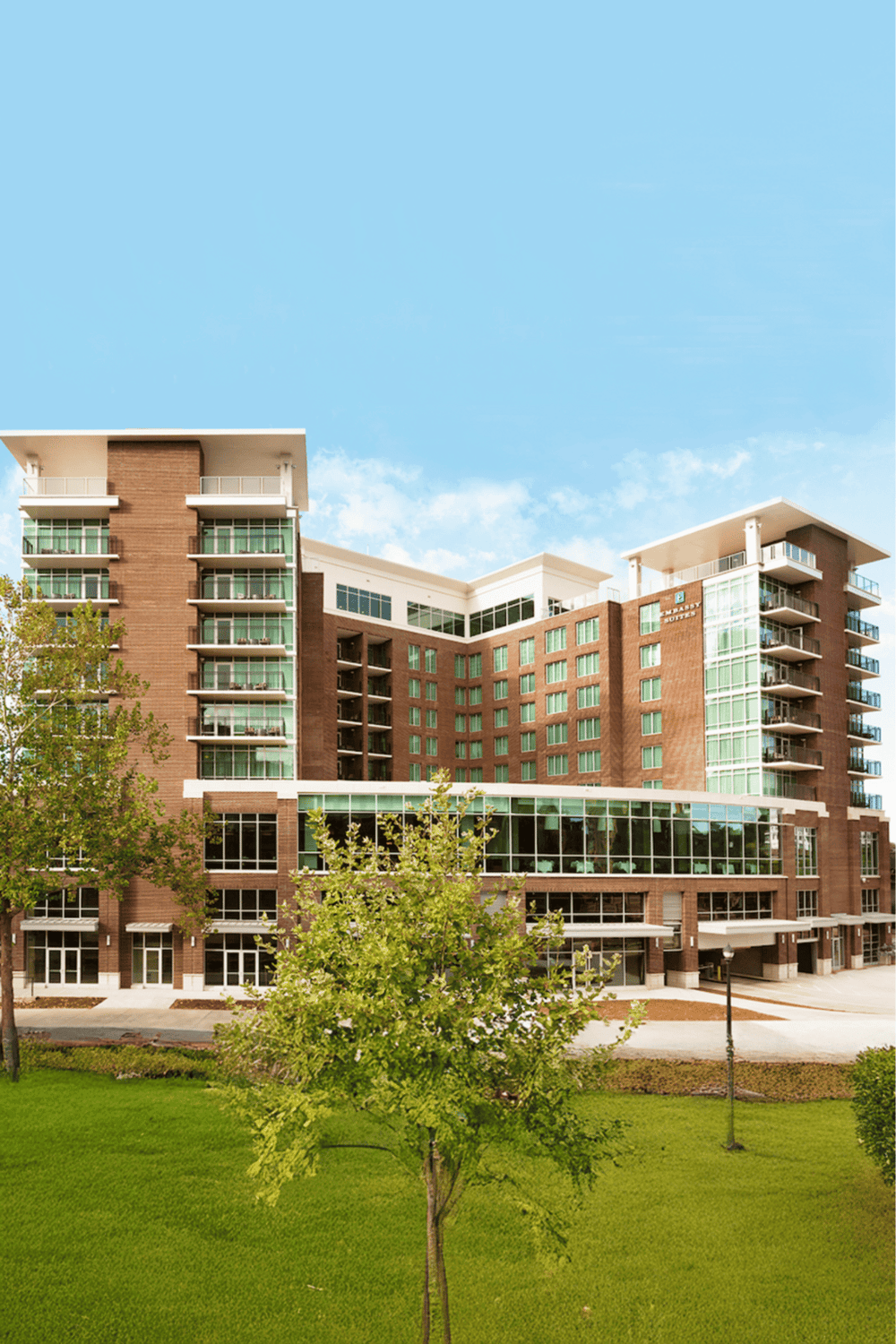 Modern luxury hotel exterior with greenery and spacious balconies, perfect for travelers seeking comfort and style.