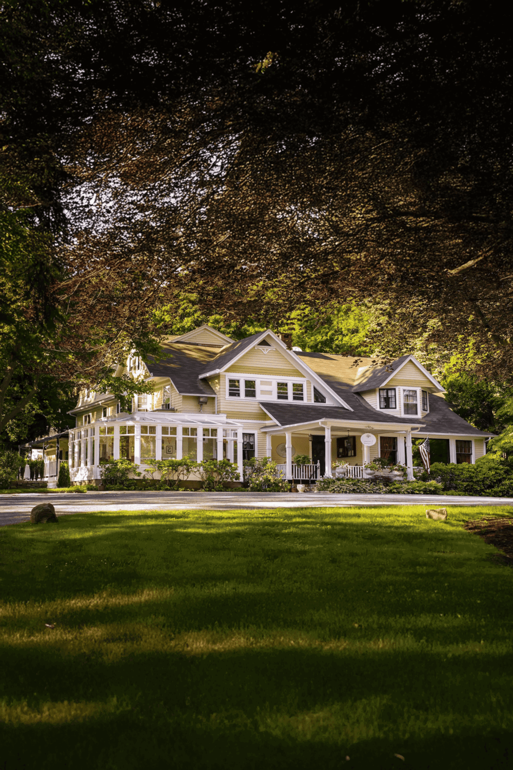 Stunning historic house surrounded by lush greenery and tall trees.