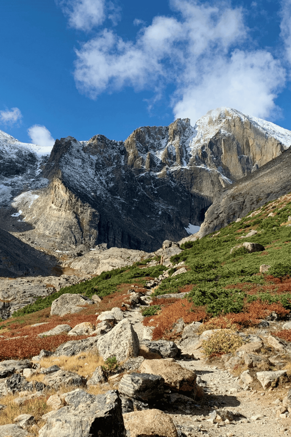 1. Snow-capped mountain trail with rocky landscape and blue sky, scenic adventure route.