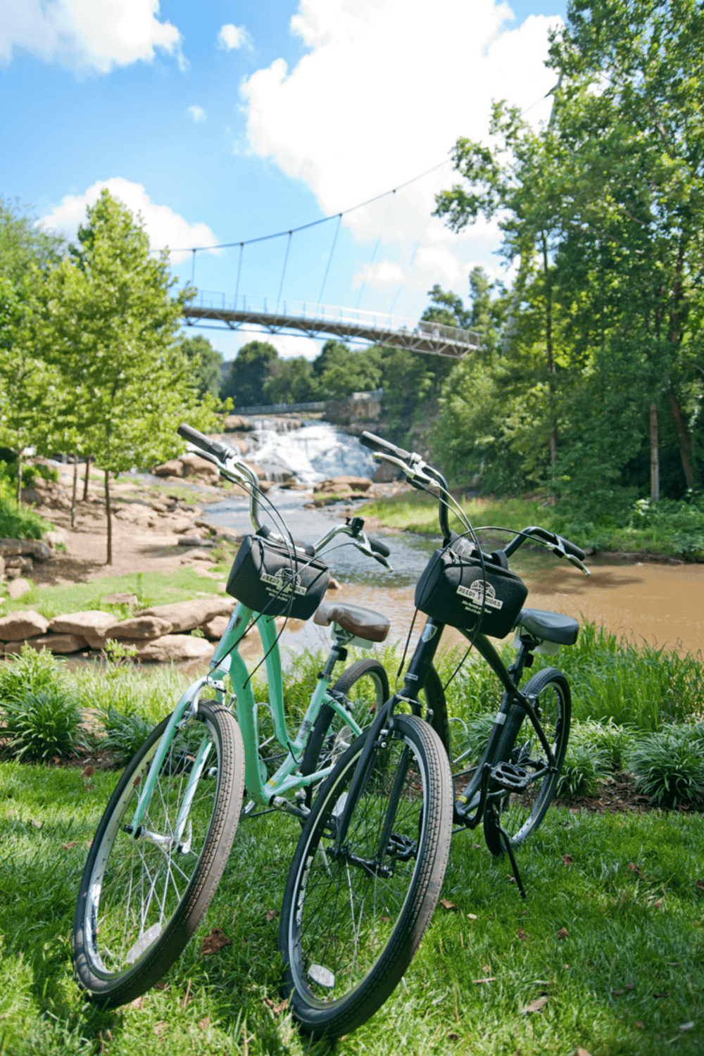 Bicycle rentals near scenic river with waterfall and suspension bridge, perfect for outdoor adventures.