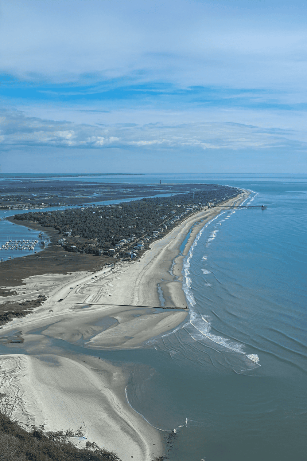Aerial view of a coastal town with beaches, waterways, and residential areas along the shoreline.