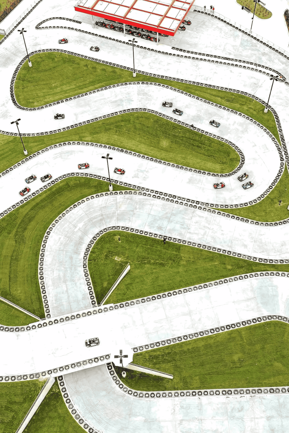 Colorful go-kart racing track with winding lanes and green grassy infield for fun outdoor activities.