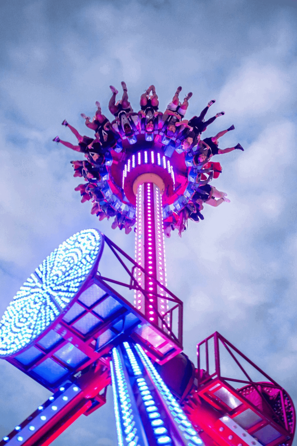 Colorful amusement park ride with illuminated spinning attraction at dusk.