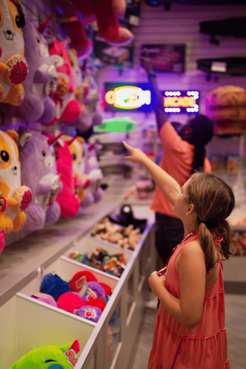 Soft plush toys at arcade game store, kids shopping for stuffed animals, colorful toy store attraction, fun destination for children and families.