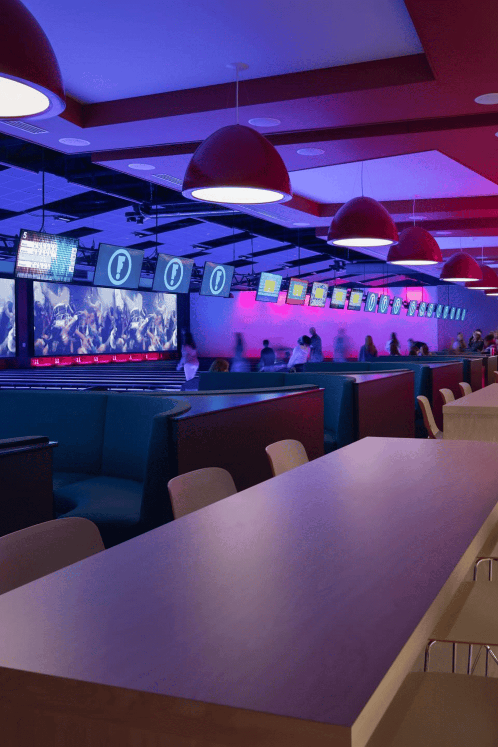 Bright modern airport lounge with large screens, stylish lighting, and seating areas for travelers.