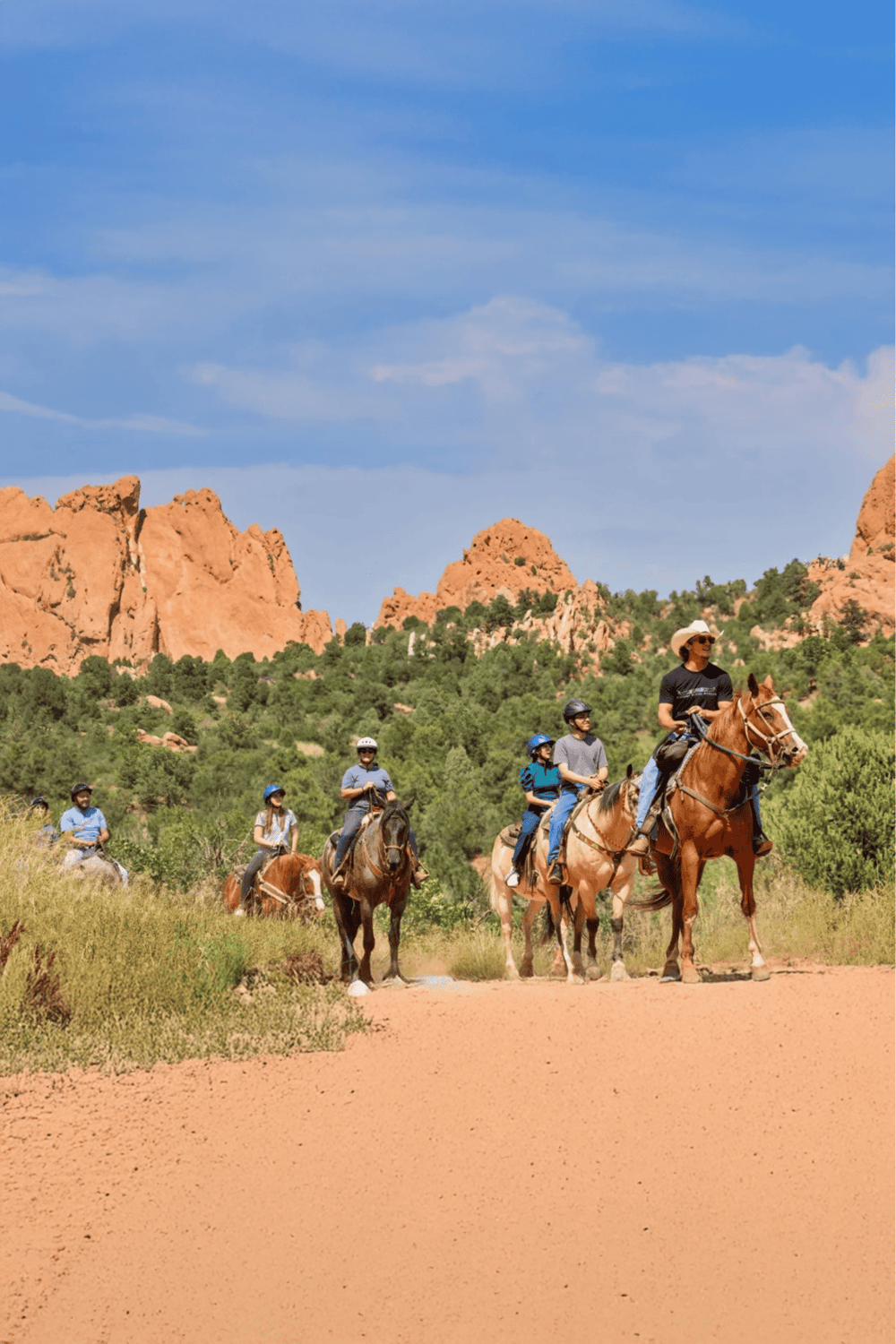 1. Group of people horseback riding in Colorado's red rock mountains, scenic outdoor adventure.