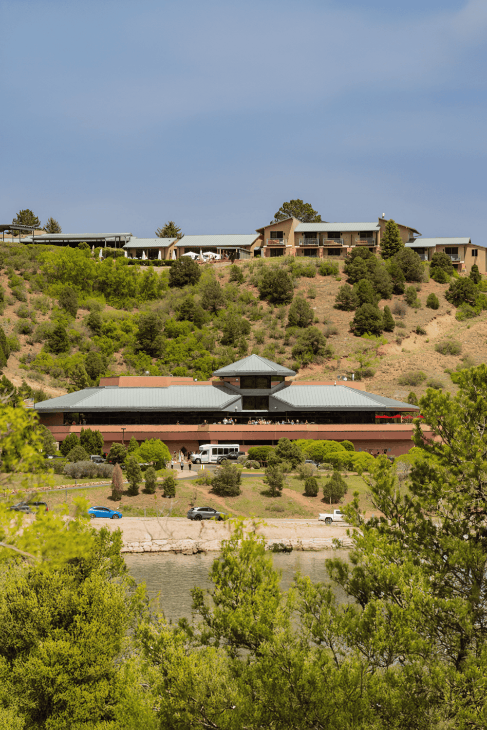 Scenic view of Quest for Directions headquarters and hillside residences in a lush, green landscape.