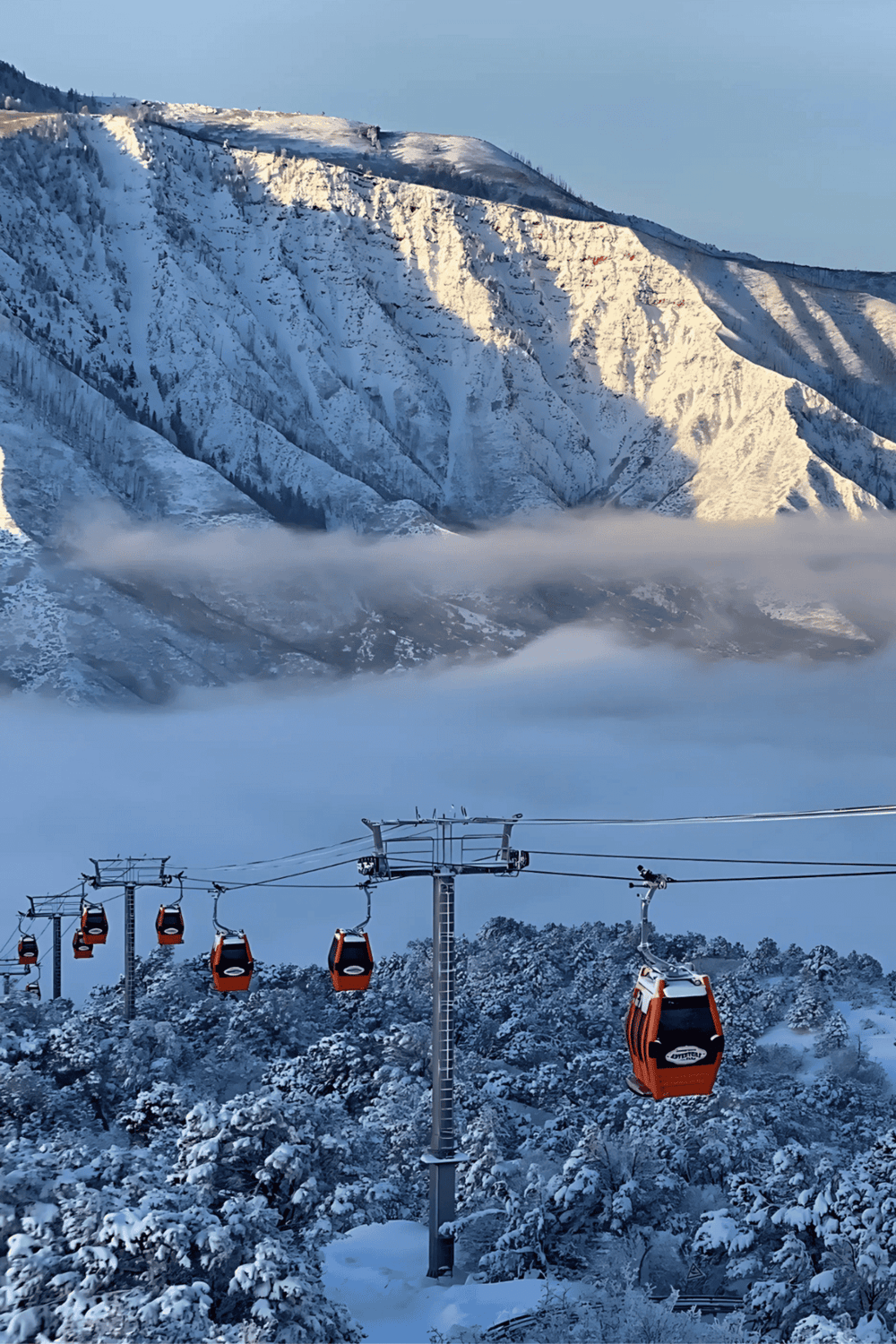 Snow-covered mountains and ski lift gondolas in a winter landscape for adventure travel.