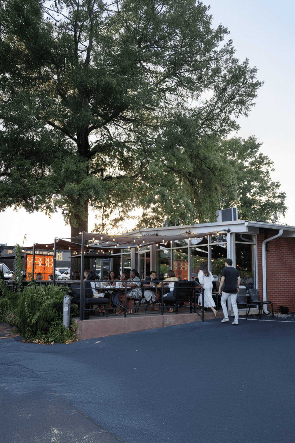 1. Outdoor dining at QuestForDirections restaurant with string lights and large tree backdrop.