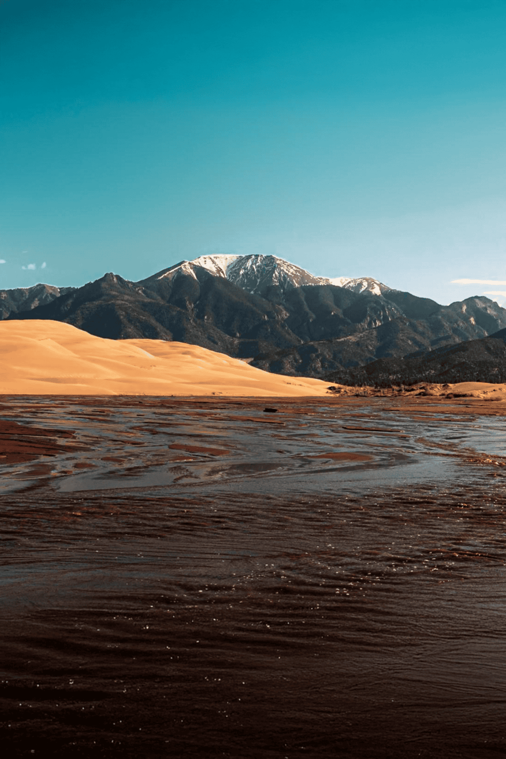 Snow-capped mountains and desert landscape with flowing waters, stunning scenery from QuestForDirections.