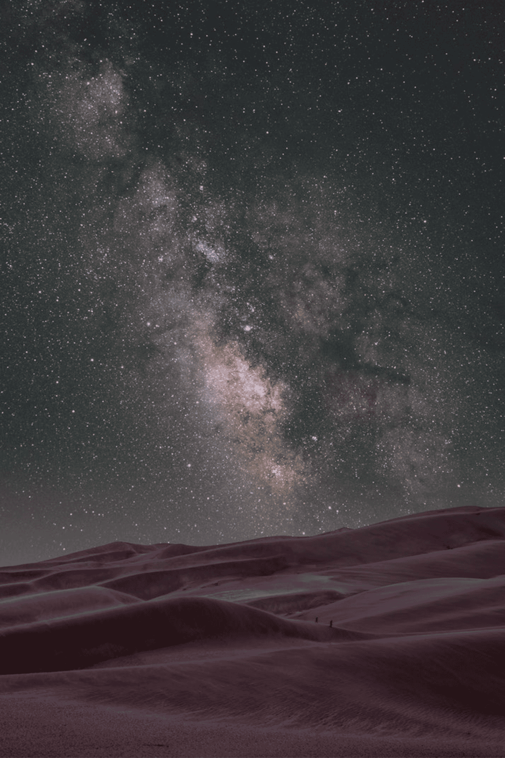 Stunning view of the Milky Way galaxy over desert dunes at night.