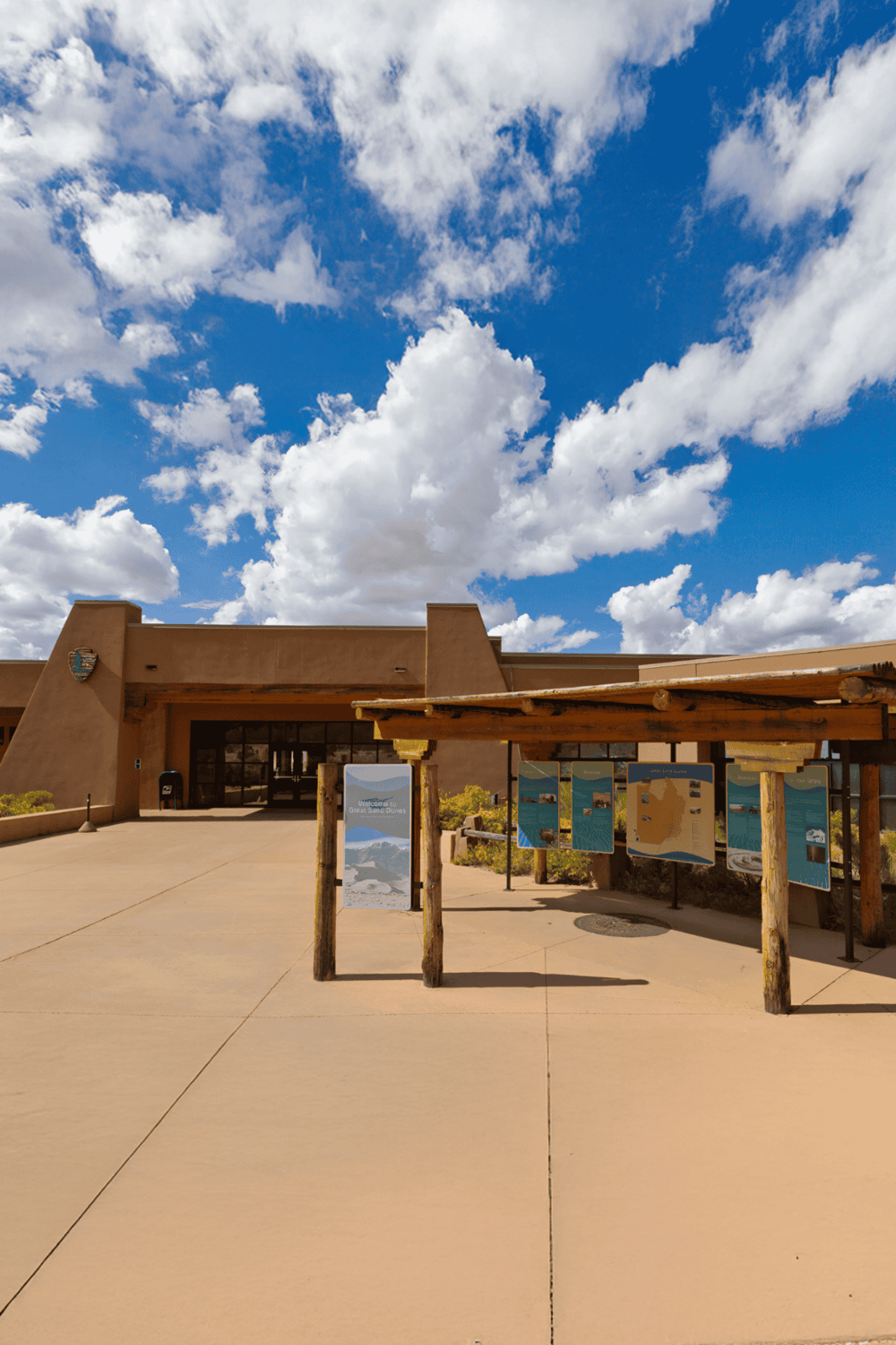 Epic desert visitor center with informational signs under blue sky.