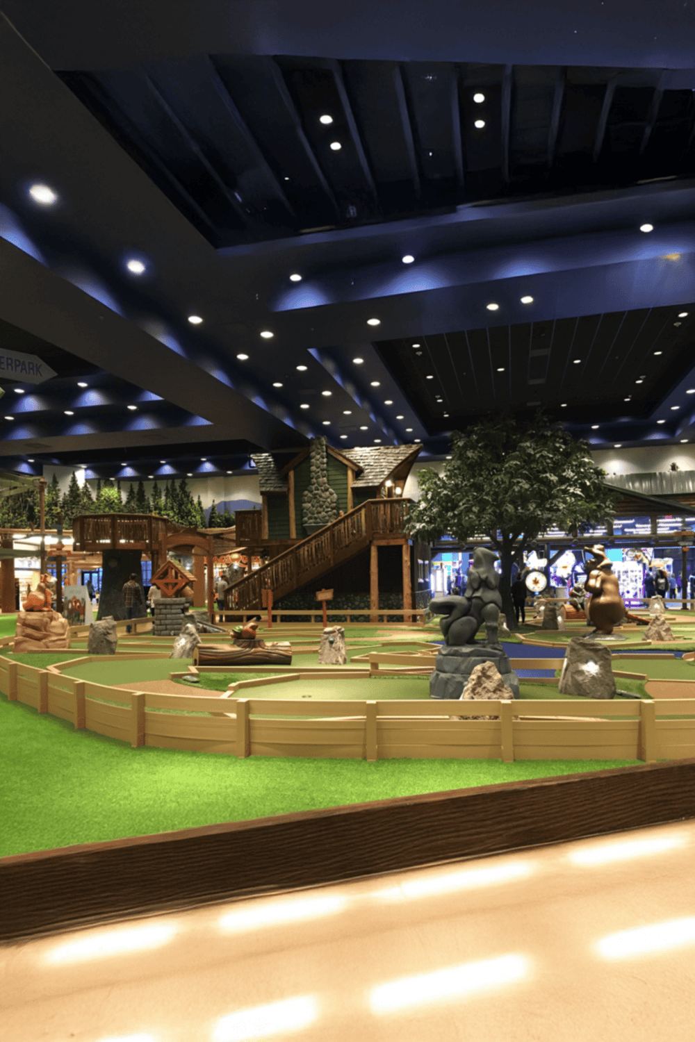Underwater mini golf course with trees and playful sculptures inside QuestForDirections shopping mall.