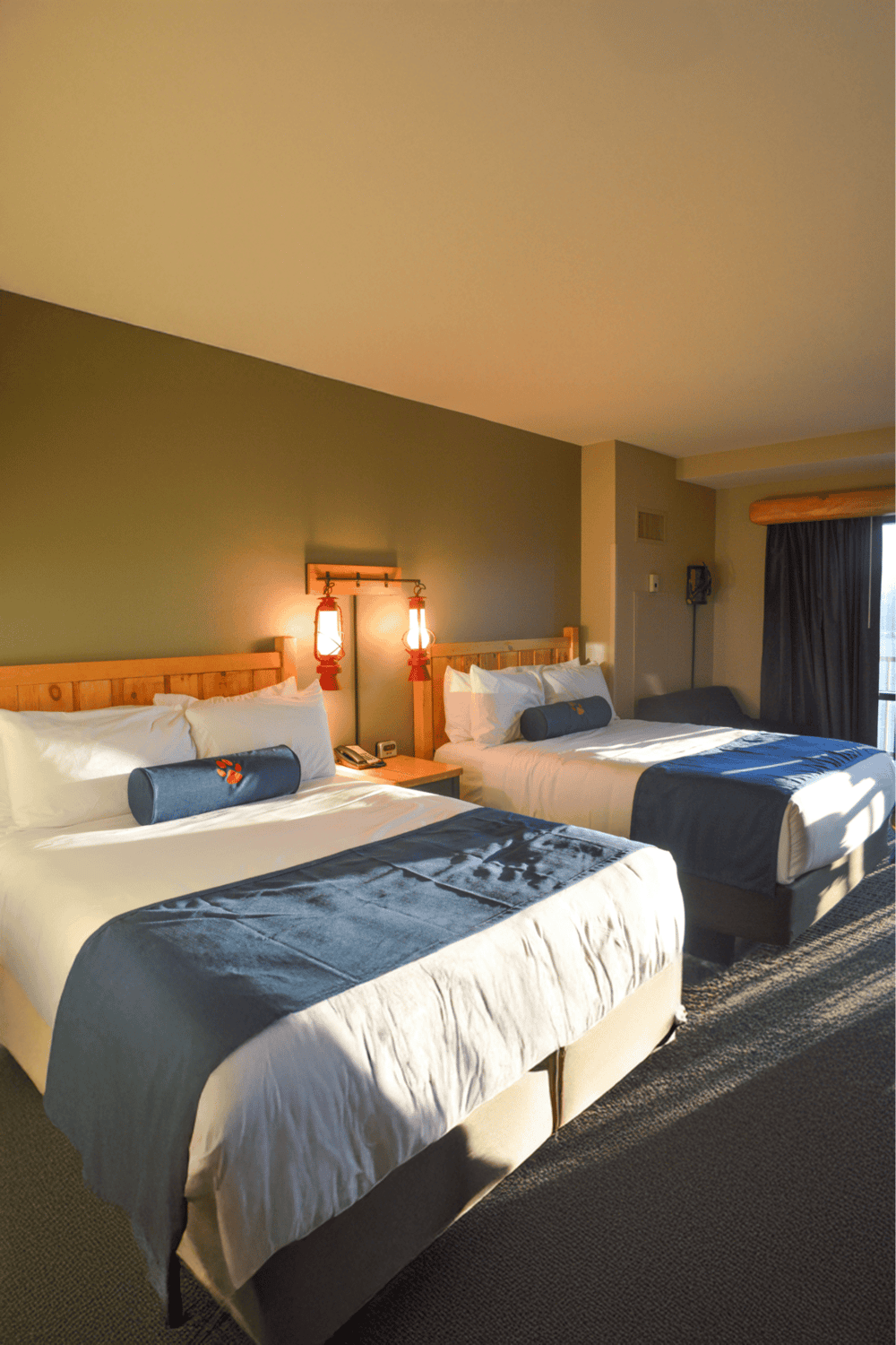 Cozy hotel room with two queen beds, wooden headboards, and rustic decor at QuestForDirections.