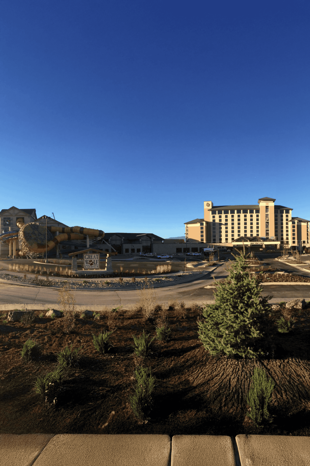 Aerial view of Quest for Directions hotel with large water slide at Great Wolf Lodge, under clear blue sky.
