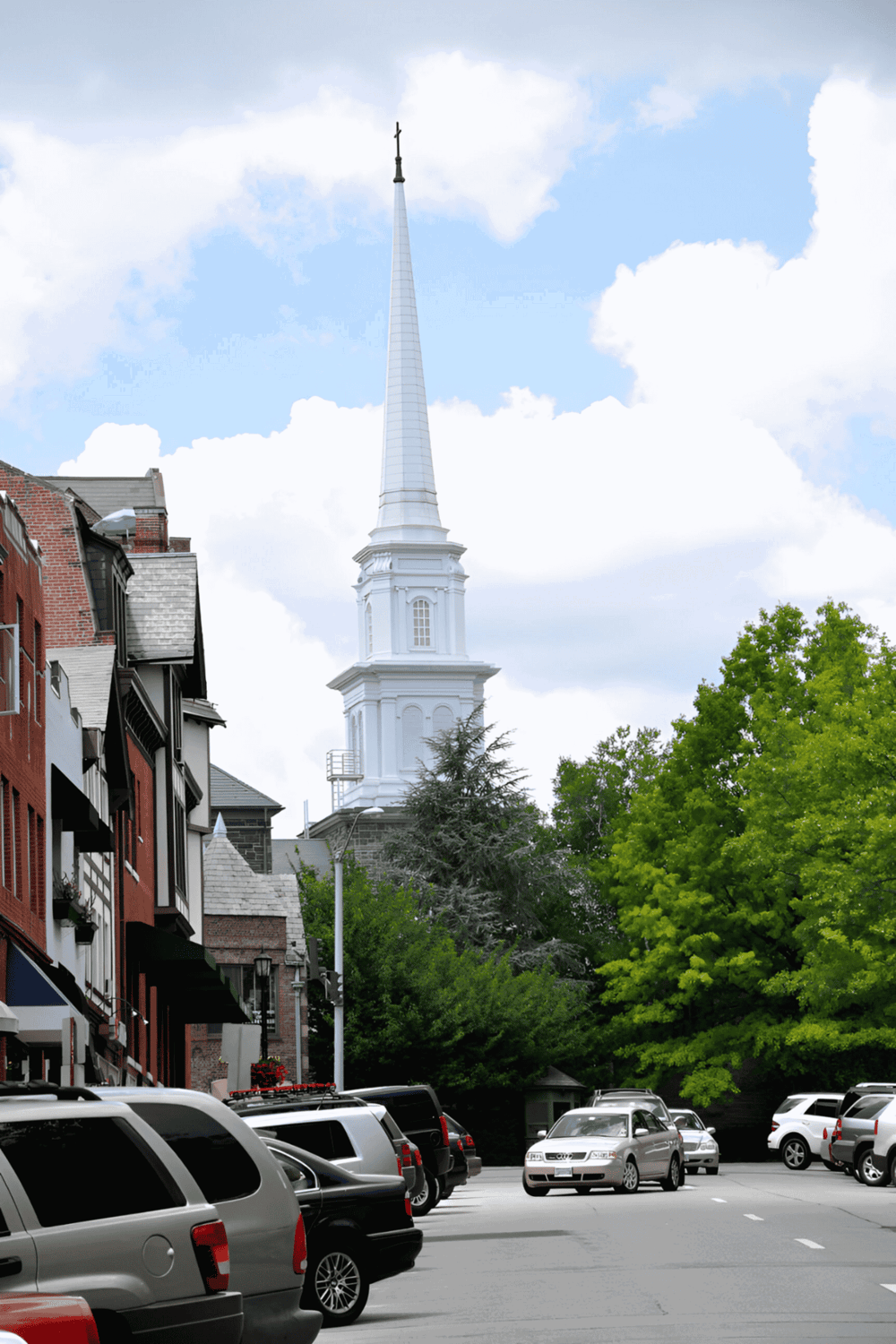Historic church steeple in downtown with parking lot and lush trees, promoting QuestForDirections.